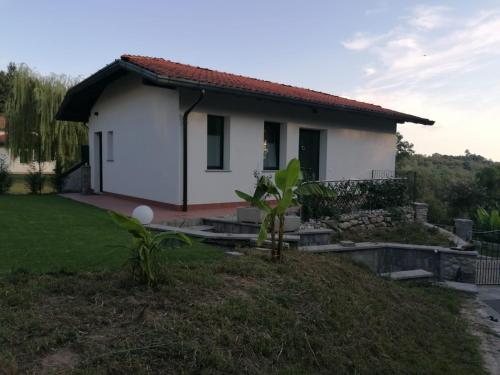une petite maison blanche avec une cour verdoyante dans l'établissement IL CILIEGIO DI ZOE, à Cerro Lago Maggiore