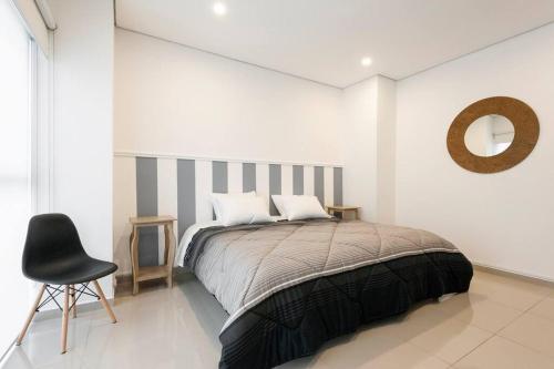 a bedroom with a bed with a chair and a mirror at Beautiful loft. King size bed. 150 Mbps internet. in Mexico City