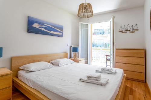 une chambre avec un lit blanc avec des serviettes dessus dans l'établissement Appartement Duchez - Welkeys, à Arcachon