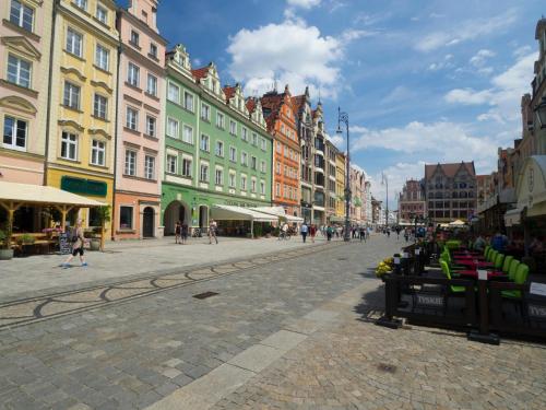 a city street with buildings and people walking on the street at AS HOME Apartamenty - Grand Designer Loft 90m2 RYNEK 505 in Wrocław