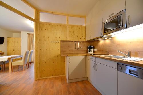 uma cozinha com um lavatório e um micro-ondas em Ferienwohnungen Plattner em Weissensee