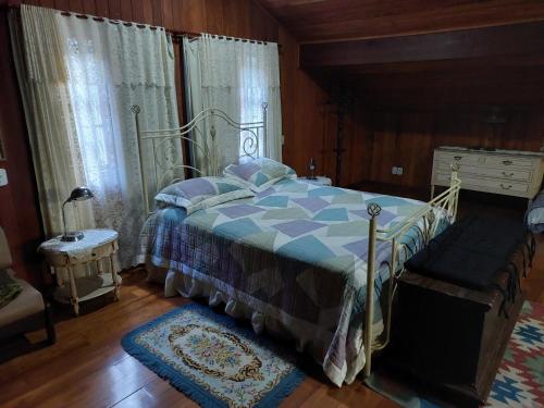 a bedroom with a bed with a blue and white comforter at Lumiar Eco Lodge - Casa Alemã in Nova Friburgo