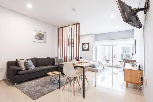 a living room with a couch and a table at Chic loft! 150 BPS fiber optic internet in Mexico City