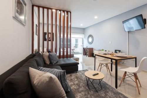 a living room with a couch and a table at Chic loft! 150 BPS fiber optic internet in Mexico City