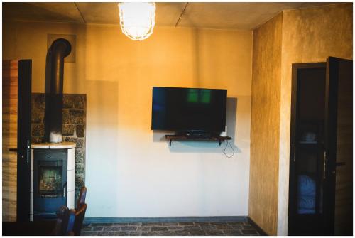 a flat screen tv on a wall in a room at Domki Loft Park in Skąpe