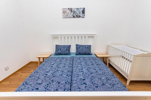 a bedroom with a crib and a blue bed at Duplex Apartment in Prague