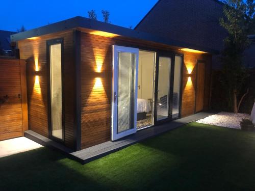 a garden room with sliding glass doors on a lawn at MeeZee Pearl Double Bed Lodge With Free Parking in Manchester
