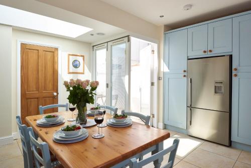 eine Küche mit Holztisch und Kühlschrank in der Unterkunft Magenta - A stunning Seafront house with lovely and uninterrupted Beach Views - Aldeburgh Coastal Cottages in Aldeburgh