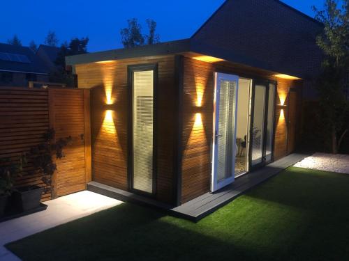 a house with lights on the side of it at MeeZee Pearl Double Bed Lodge With Free Parking in Manchester