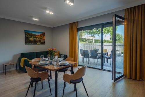 a dining room and living room with a table and chairs at Apartament Widok 1 in Piechowice