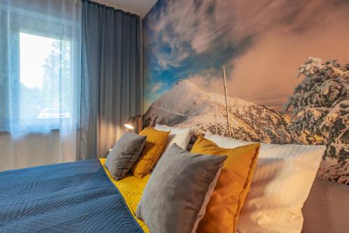a bedroom with a bed with pillows and a painting at Apartament Widok 1 in Piechowice
