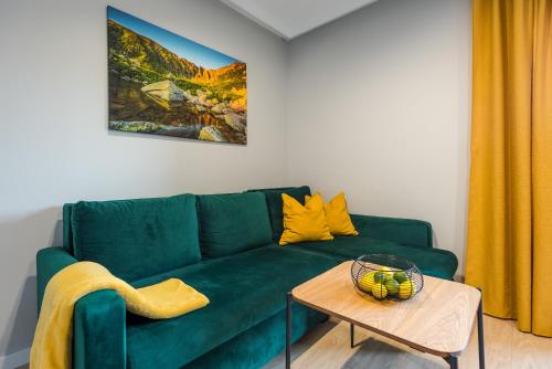 a green couch in a living room with a table at Apartament Widok 1 in Piechowice