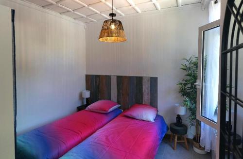 - 2 lits dans une chambre avec des oreillers rouges et bleus dans l'établissement Superbe T3 moderne front de mer/ 2 Balcons 2 Chmbr, à Saint-Cyr-sur-Mer