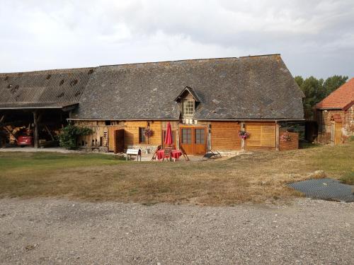 an old barn with a table and chairs in front of it at GITE DE CHARME SUR LA COTE D'ALBATRE in Saint-Aubin-sur-Mer