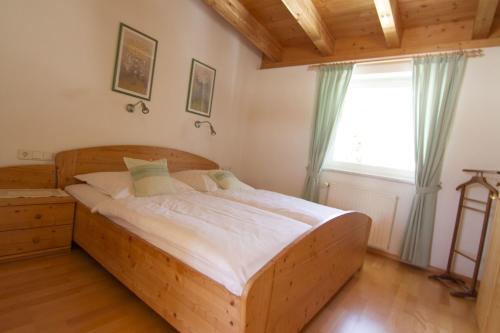 a wooden bed in a room with a window at Appartements Erhol dich gut in Leutasch