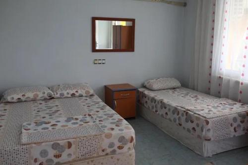 1 dormitorio con 2 camas y espejo en Ümit 2 Termal Apart Pansiyon, en Pamukkale