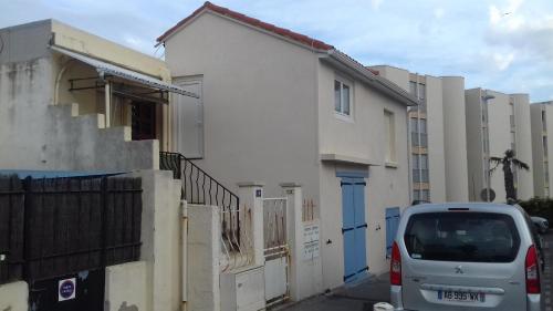 une camionnette blanche garée devant un immeuble dans l'établissement Hippocampe - Jolie petite Maison de vacances à la Corniche, à Sète