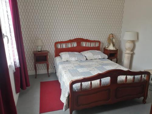 um quarto com uma cama grande e uma cabeceira vermelha em Gîte de la Casse em Channay-sur-Lathan