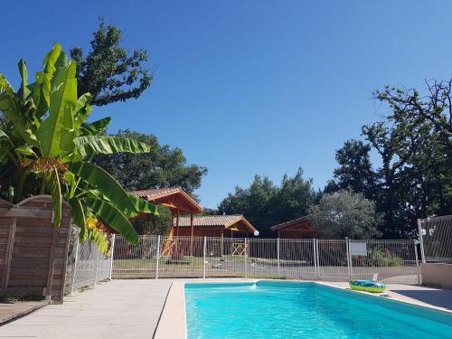 Fronton的住宿－Les gîtes des Palombes，一个带围栏的院子内的游泳池