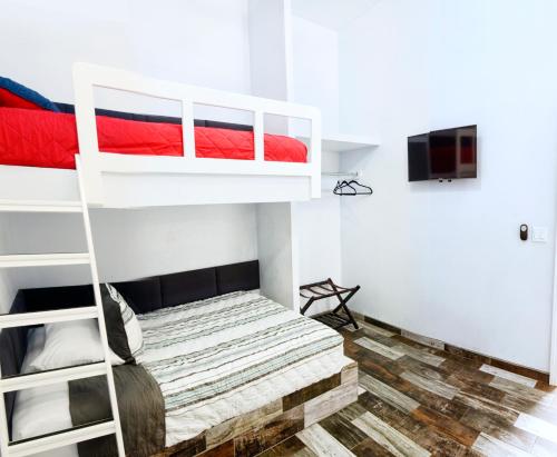 1 dormitorio con 2 literas y TV en Popotla Villa #204, en Divisadero
