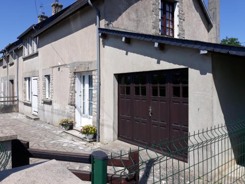 um edifício com uma porta castanha ao lado em chez Jean-Marc et Colette em Le Molay-Littry