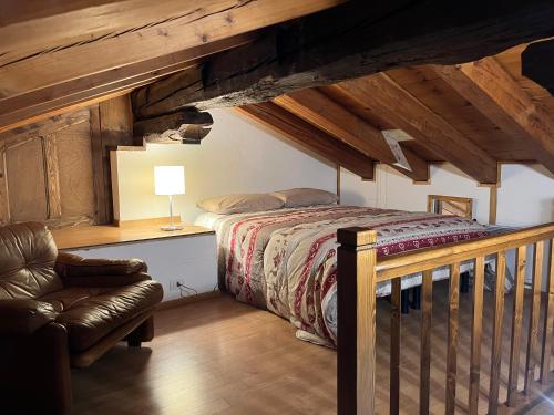 a bedroom with a bed and a chair in a attic at Chalet Blanc "Coeur Sapin" in Courmayeur