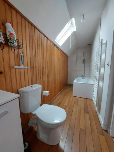 uma casa de banho com um WC e uma banheira em chez Jean-Marc et Colette em Le Molay-Littry