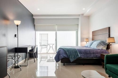 a bedroom with a bed and a table and a desk at 600 sq ft in trendy area, 150 BPS fiber optic in Mexico City