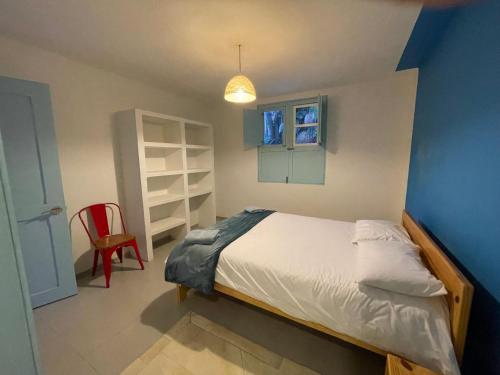 um quarto com uma cama e uma cadeira vermelha em Casita Azul em Salento