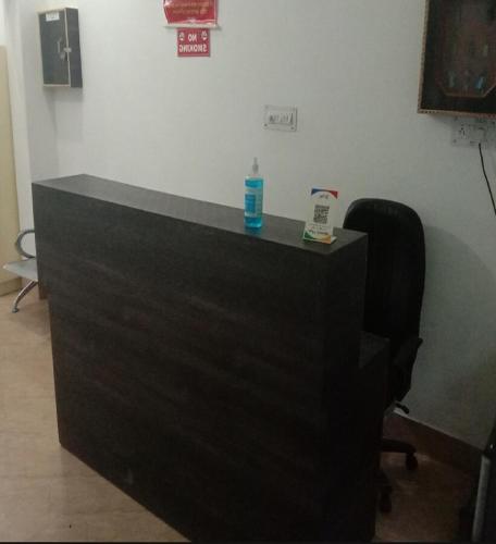 a black desk with a bottle and a chair in a room at HOTEL PUSPWAN AND RESTAURANT by StayApart in Ukhimath