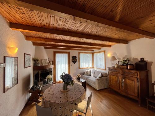 ein Wohnzimmer mit einem Tisch und einem Sofa in der Unterkunft Chalet Blanc "Le Flocon" in Courmayeur