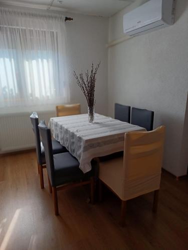 a dining room table with a vase on top of it at Apartman Šoljac in Perušić