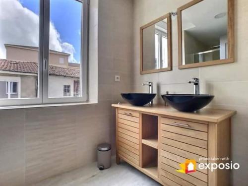 a bathroom with two sinks and a large window at Maison de ville avec petite cour in Saint-Mihiel
