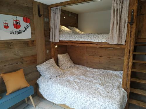 - une chambre avec 2 lits superposés et une chaise dans l'établissement Le Montana - Studio rue du Centre - Cosy et Montagnard - Navette, aux Gets