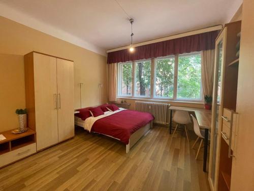 a bedroom with a bed with red pillows and a desk at Home in the Heart in Budapest