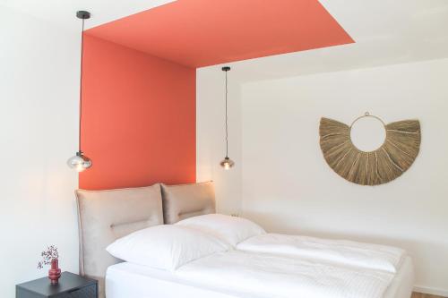 een bed in een kamer met een oranje muur bij African-Style Apartment in Koblenz