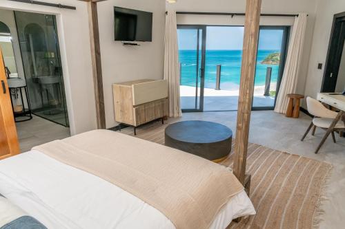 a bedroom with a bed and a view of the ocean at Tamarind Hills Resort & Villas in Johnsons Point