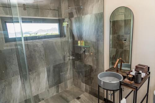 a bathroom with a shower and a sink and a mirror at Tamarind Hills Resort & Villas in Johnsons Point