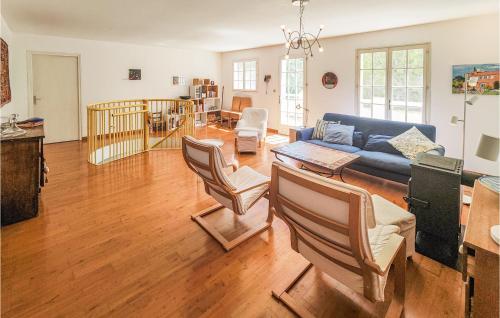 un salon avec un canapé bleu et des chaises dans l'établissement 3 Bedroom Nice Home In Fouzilhon, à Fouzilhon