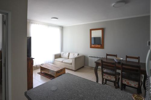 a living room with a table and a chair at Departamento de una dormitorio - CRESPO in Santa Fe