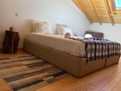 a bedroom with a large bed with a rug at Casa de Xisto Ti Maria in Videmonte