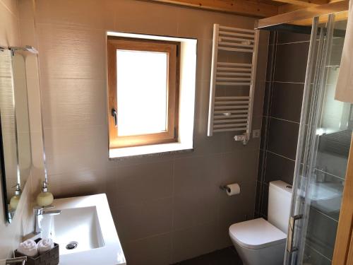 a bathroom with a sink and a toilet and a window at Casa de Xisto Ti Maria in Videmonte