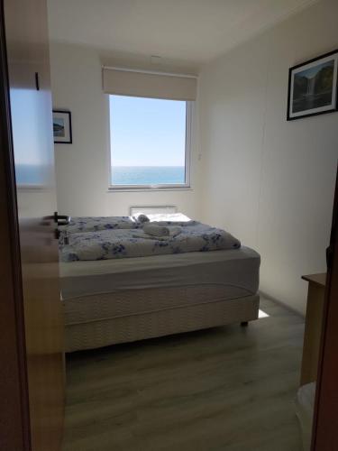 a bedroom with a bed and a window at Rauðsdalur in Brjánslækur