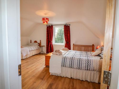 a bedroom with two beds and a window at Beehive Cottage in Kilbrittain