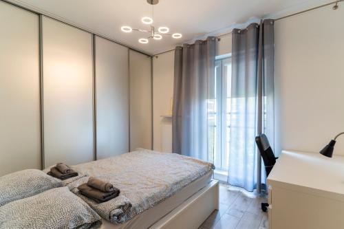 a bedroom with a bed and a window at FIRST -- Green Żoliborz Apartment 5 in Warsaw