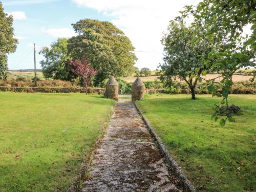 a path through a field with a fence at Beehive Cottage in Kilbrittain