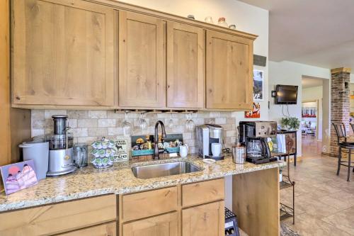 a kitchen with wooden cabinets and a sink at Fruita Victorian Home with Hot Tub and Mountains! in Fruita