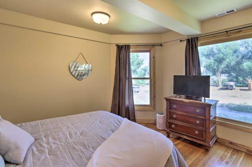 a bedroom with a bed and a television on a dresser at Fruita Victorian Home with Hot Tub and Mountains! in Fruita
