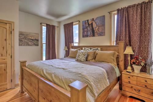 a bedroom with a bed and a dresser and windows at Fruita Victorian Home with Hot Tub and Mountains! in Fruita