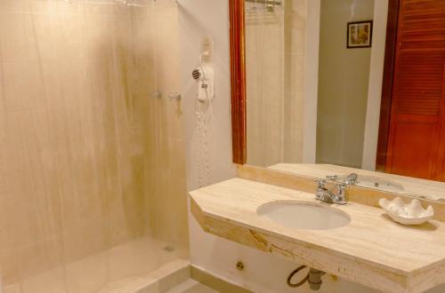 a bathroom with a sink and a shower at Hotel Faranda Express Puerta Del Sol Barranquilla, A Member of Radisson Individuals in Barranquilla